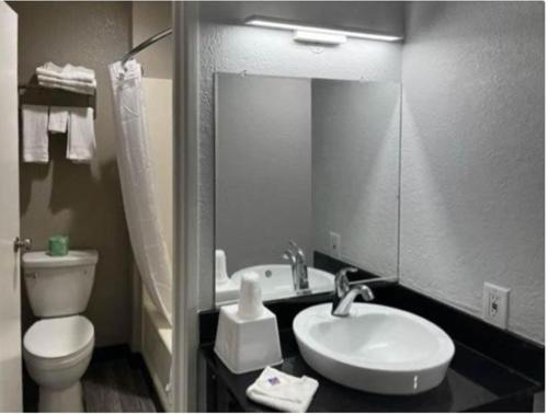 a bathroom with a sink and a toilet and a mirror at Motel 6 Little Rock AR South in Little Rock