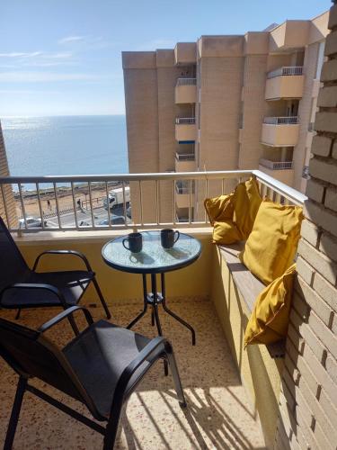 ein Balkon mit Tisch und Stühlen und dem Meer in der Unterkunft Sea View Luxury Apartment Victoria in Torrevieja