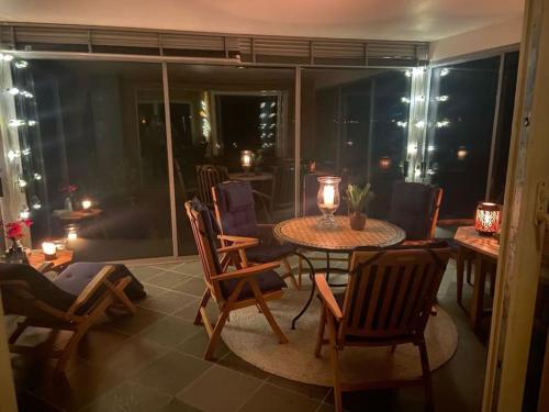 Tranøya的住宿－Drømmehytta på Senja，一间带桌椅的客厅和一间带阳台的房间