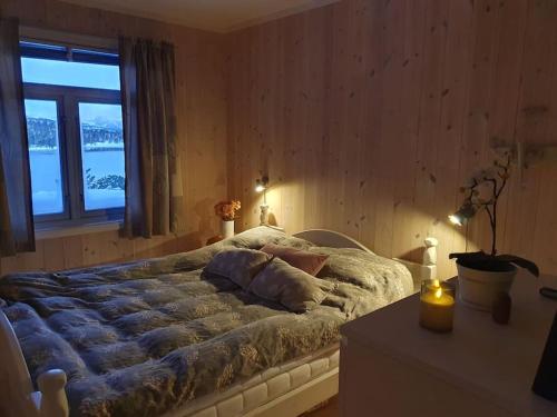 - une chambre avec un grand lit et une fenêtre dans l'établissement Drømmehytta på Senja, à Tranøya