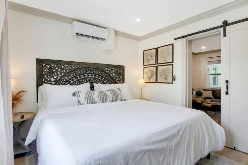 a white bedroom with a large white bed with pillows at Lovely 1 Bedroom - Walk to Waterfront in West Palm Beach