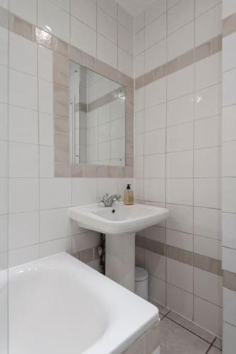 a white bathroom with a sink and a mirror at Beautiful 1 Bed Flat close to Regents Park in London