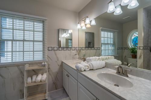 a bathroom with a sink and a large mirror at Luxury Beachside Vacation Getaway - OceanView, Movie Theatre, Mini Golf in Atlantic City