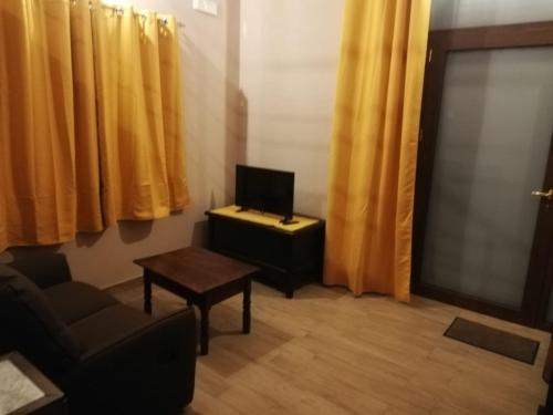 a living room with a tv and a chair and a table at VILLA VIRGINIA in Piazza Armerina