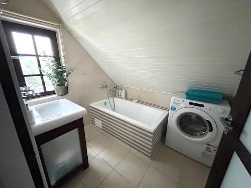 a bathroom with a sink and a washing machine at Wałpusz Holiday Home in Szczytno