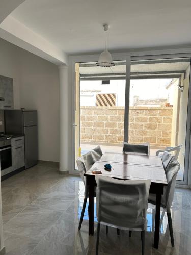 eine Küche und ein Esszimmer mit einem Tisch und Stühlen in der Unterkunft Casa vacanza Salento in Aradeo