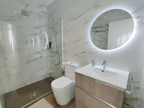 a bathroom with a toilet and a sink and a mirror at Apartamento Mar & Sal in Mindelo