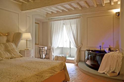 1 dormitorio con cama y ventana grande en The house with steam room, jacuzzi and theater view, en Cortona