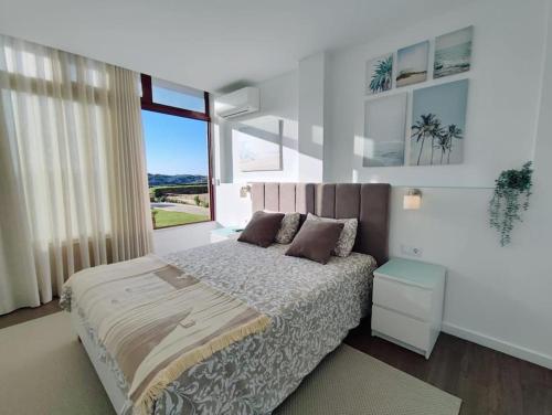 a bedroom with a bed and a large window at Apartamento Mar & Sal in Mindelo