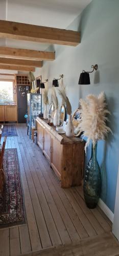 a room with a table with a vase with feathers in it at Lake House by NIVO in Pavlovci