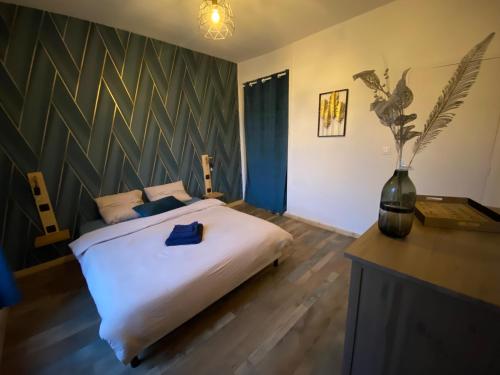 a bedroom with a large bed and a vase at - Le backpacker - logement atypique et spacieux en résidence avec ascenseur in Nevers