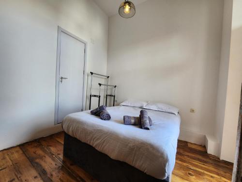 a bedroom with a large bed with white walls and wooden floors at Sunny house in Tbilisi City