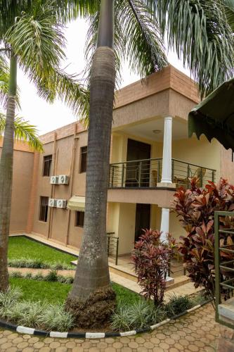 a building with palm trees in front of it at The Country Inn by Smart Haven in Kigali