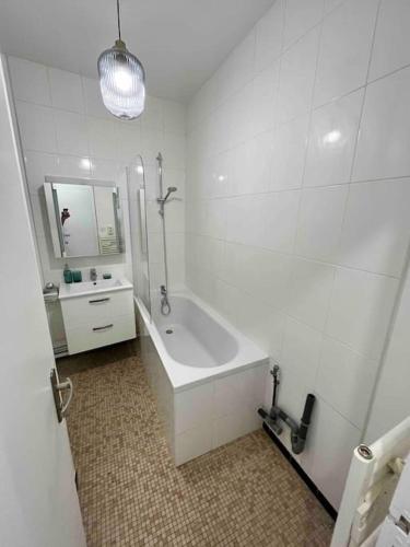 une salle de bain blanche avec une baignoire et un lavabo dans l'établissement Bel appartement dans l’hyper centre de Nantes, à Nantes
