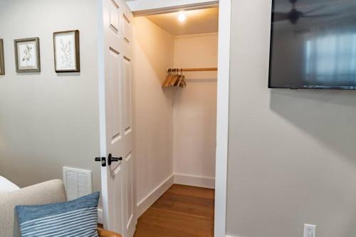 a room with a tv and a door with a couch at Renovated Downtown Apartment - B in West Palm Beach