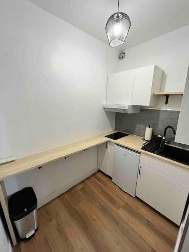 une cuisine avec des armoires blanches et un comptoir en bois dans l'établissement Bel appartement dans l’hyper centre de Nantes, à Nantes