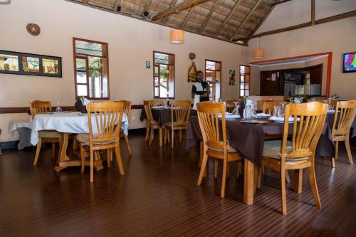 a dining room with tables and chairs in a restaurant at The Country Inn by Smart Haven in Kigali