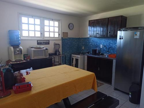 una cocina con una mesa con un mantel amarillo. en Privê Recanto da Enseada - Serrambi, en Porto de Galinhas