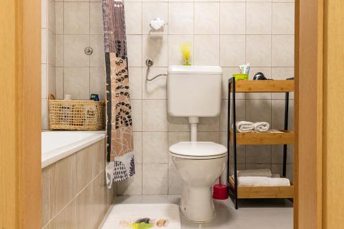 a bathroom with a toilet and a bath tub at Vikendica Bjelašnica Lukavac in Bjelašnica