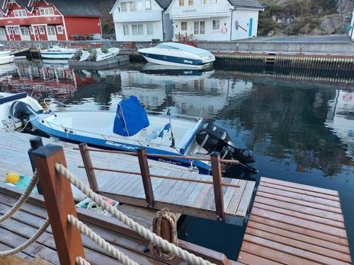 a small blue boat tied up to a dock at Rorbu i Austevoll med 3 soverom og mulighet for båtleie in Kolbeinsvik