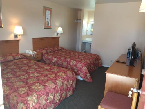 Habitación de hotel con 2 camas y TV en American Motel, en San Antonio