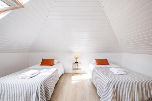 two beds in a room with white ceilings at AGUIAR´S VILLAGE in Ribeira Brava