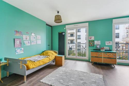 1 dormitorio con 1 cama, escritorio y 2 ventanas en Maison duplex avec jardin, en Saint-Ouen