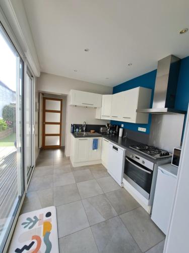 une cuisine avec des armoires blanches et un sol carrelé dans l'établissement Belle maison berckoise, à Berck-sur-Mer