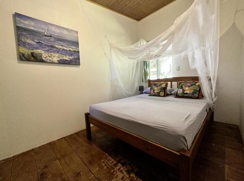 a bedroom with a bed with a mosquito net at Casa Morpho Uvita Guesthouse in Uvita