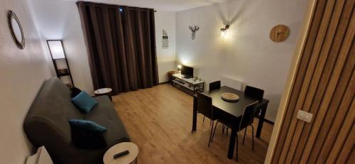 a living room with a couch and a table with chairs at Appartement Saint Lary - pla d'adet - aux pieds des pistes in Saint-Lary-Soulan