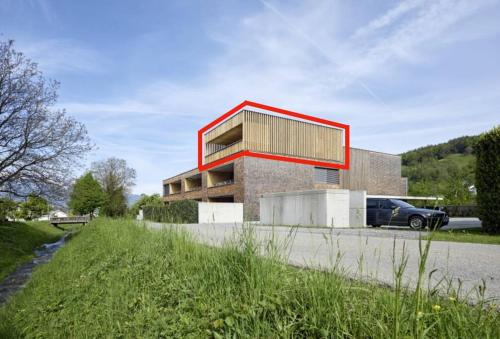 un edificio con techo rojo al lado de una carretera en Penthousewohnung mit Bergblick - klimatisiert, en Klaus