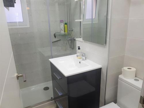 a white bathroom with a sink and a shower at PRIMERA LINEA DE PLAYA-CULLERA in Cullera