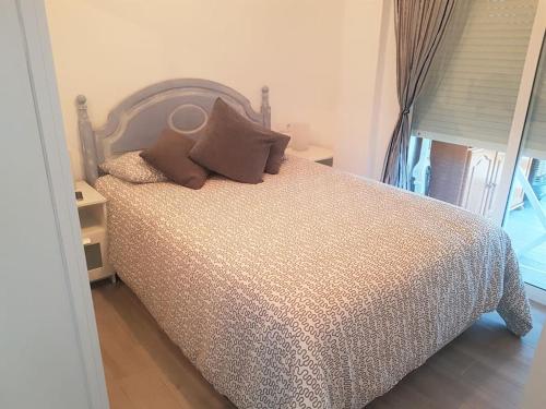 a bedroom with a bed with pillows on it at PRIMERA LINEA DE PLAYA-CULLERA in Cullera
