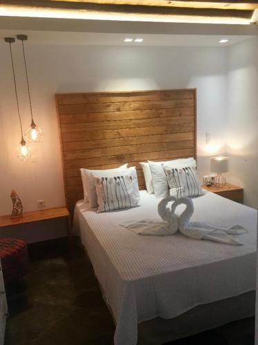 a bedroom with a large bed with a wooden headboard at PANORAMIO in Batsi