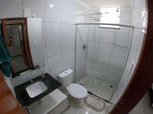 a small bathroom with a toilet and a shower at Apartamento 2 quartos na área central perto do GV Shopping in Governador Valadares