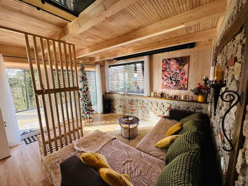 een woonkamer met een bank en een kerstboom bij Romantic cabin with hot/cold tub and finnish sauna in Šentvid pri Stični