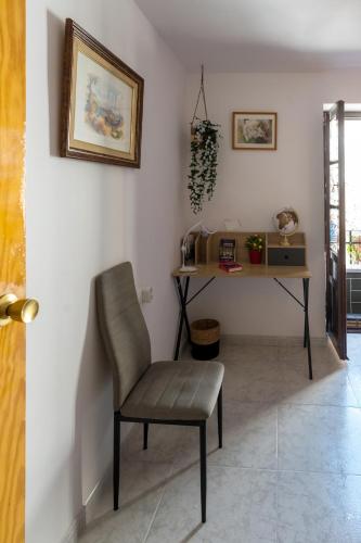 a chair in a room with a table and a desk at Casa Asia in Granada