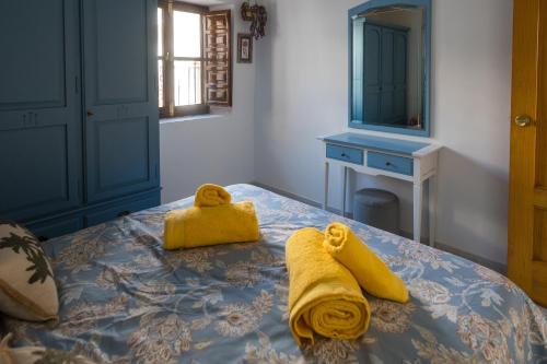 a bedroom with a bed with yellow towels on it at Casa Asia in Granada