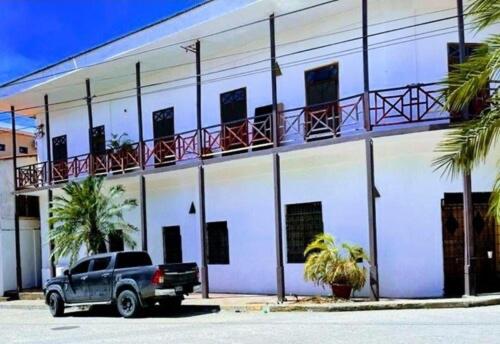 a truck parked in front of a white building at Bless in Tela