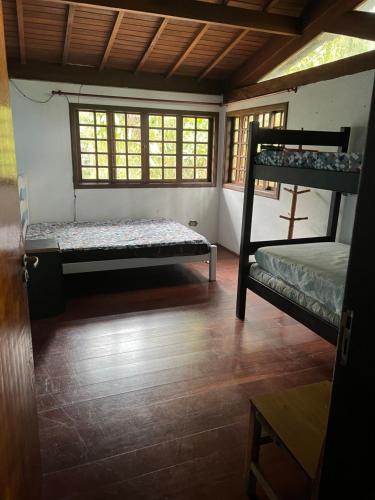 a room with two bunk beds and a window at Casa próxima ao mar, Camburi. in São Sebastião