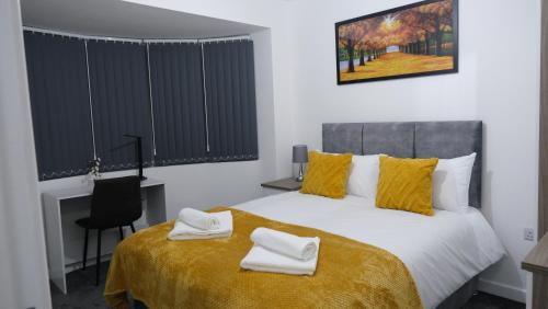 a bedroom with a bed with two towels on it at Modernized Three Bedroom House near City Stadium, Attractions, City Centre - Sky n Netflix - Convenient Transport in Manchester
