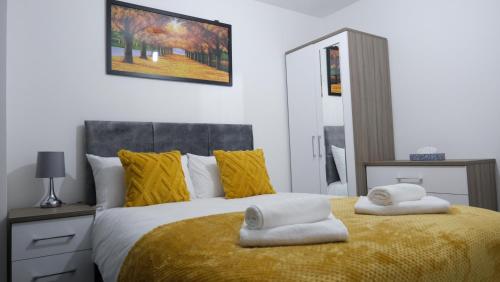 a bedroom with a bed with two towels on it at Modernized Three Bedroom House near City Stadium, Attractions, City Centre - Sky n Netflix - Convenient Transport in Manchester