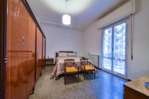 Un dormitorio con una cama y una mesa y sillas. en Da nonna Agnese, en Savona