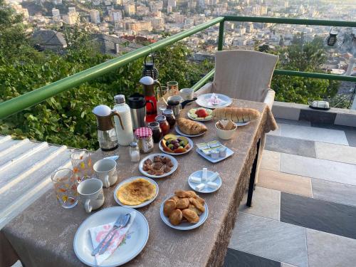 una mesa con platos de comida en el balcón en Panoramic View Guest House, en Gjirokastra