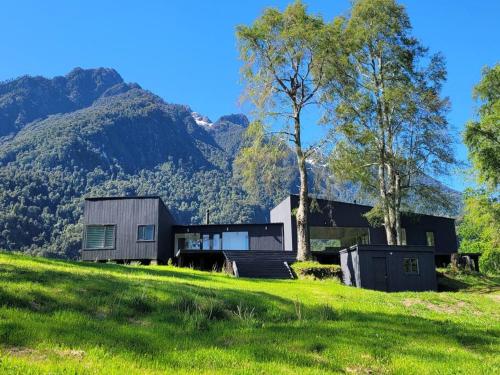 une maison sur une colline avec des montagnes en arrière-plan dans l'établissement Casa de campo sobre el rio, à llifen