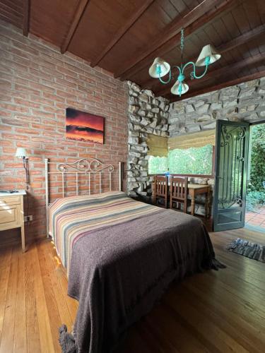 a bedroom with a bed and a stone wall at Cabañas Arehue in Mar del Plata
