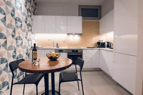 a kitchen with a table with chairs and a bottle of wine at Xenia's Cozy Apartment (near Acropolis Museum) in Athens