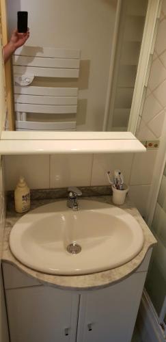 - un lavabo avec miroir et une personne prenant une photo dans l'établissement Pied des pistes La Foux d'Allos, à Allos