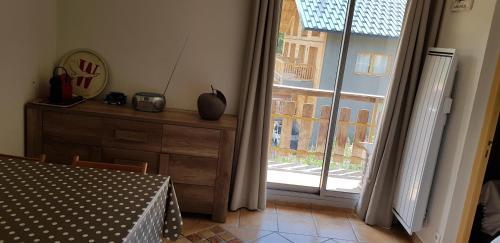 une pièce avec une table et une grande fenêtre dans l'établissement Pied des pistes La Foux d'Allos, à Allos