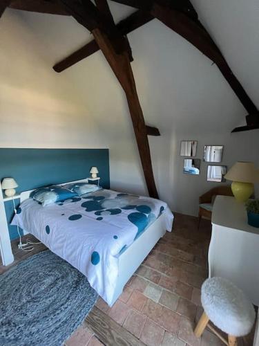 une chambre avec un lit et une chaise dans une pièce dans l'établissement La maison de Typère, à Candes-Saint-Martin
